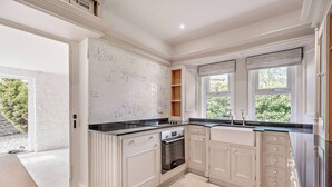Eine moderne Küche mit weißen Schränken, einer schwarzen Arbeitsplatte und einem eingebauten Backofen.