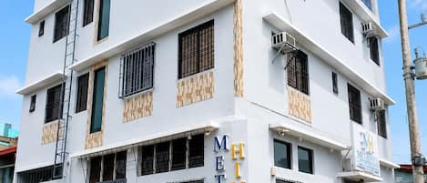 Un immeuble à plusieurs étages, doté d’une façade blanche, de nombreux balcons et d’une enseigne indiquant qu’il s’agit d’un hôtel.