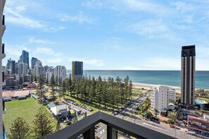 A coastal cityscape with high-rise buildings, a beach, and a parking lot. - Opus 2 Bedroom Ocean (Broadbeach)