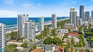 Paisatge urbà costaner amb edificis alts, una platja i un cel serè.