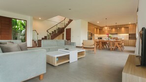 A modern living room with a sofa, coffee table, and a staircase leading to an upper level. - Ombak D3 Villa by Betterplace (Cemagi)