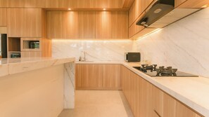 A modern kitchen with wooden cabinets, a marble countertop, and a stainless steel range hood. - Ombak D3 Villa by Betterplace (Cemagi)