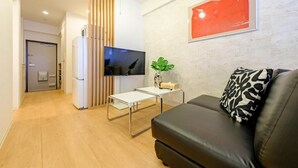 A modern living room with a flat-screen TV, a sofa, a coffee table, and a wall-mounted painting. - Choujamaru bill (Shinagawa-ku,Kamiosaki)