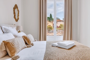 A hotel room with a bed, a view of the outside, and a balcony. - "La Grande Terrasse" Apartment with 40m2 Private Terrace, Wi-Fi, and Air Conditioning (Cannes)