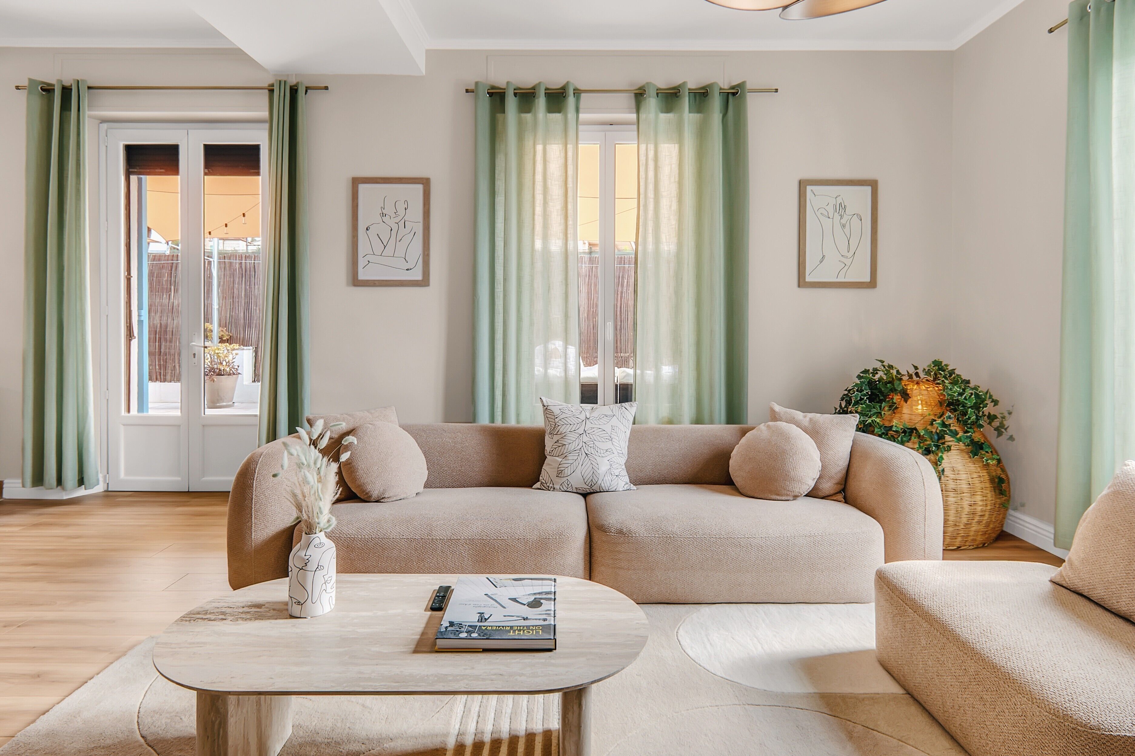 Un salon avec un canapé d’angle beige, une table basse et une plante en pot.