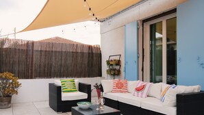 An outdoor seating area with a sofa, two armchairs, a coffee table, and a decorative plant. - "La Grande Terrasse" Apartment with 40m2 Private Terrace, Wi-Fi, and Air Conditioning (Cannes)