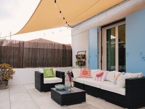 An outdoor seating area with a sofa, two armchairs, a coffee table, and a decorative plant. - "La Grande Terrasse" Apartment with 40m2 Private Terrace, Wi-Fi, and Air Conditioning (Cannes)