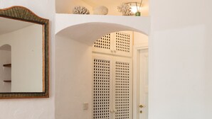 Una sala de estar con un sofá, una revista y un espejo.
