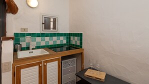 Cocina compacta con un lavamanos, una ventana y un espejo.
