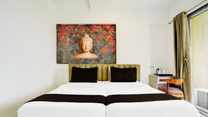 A hotel room with a double bed, a headboard, a bedside table with a kettle, cups, and a tray, and a large Buddha statue on the wall. - Collection O Jupiter Hospital Thane West (Mumbai)