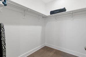 Ein Raumeck mit weißen Wänden, Holzdielen und einer Decke mit Schienensystem.