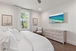 Ein Schlafzimmer mit einem Bett, einem Schminktisch, einem Stuhl und Bildern an den Wänden.