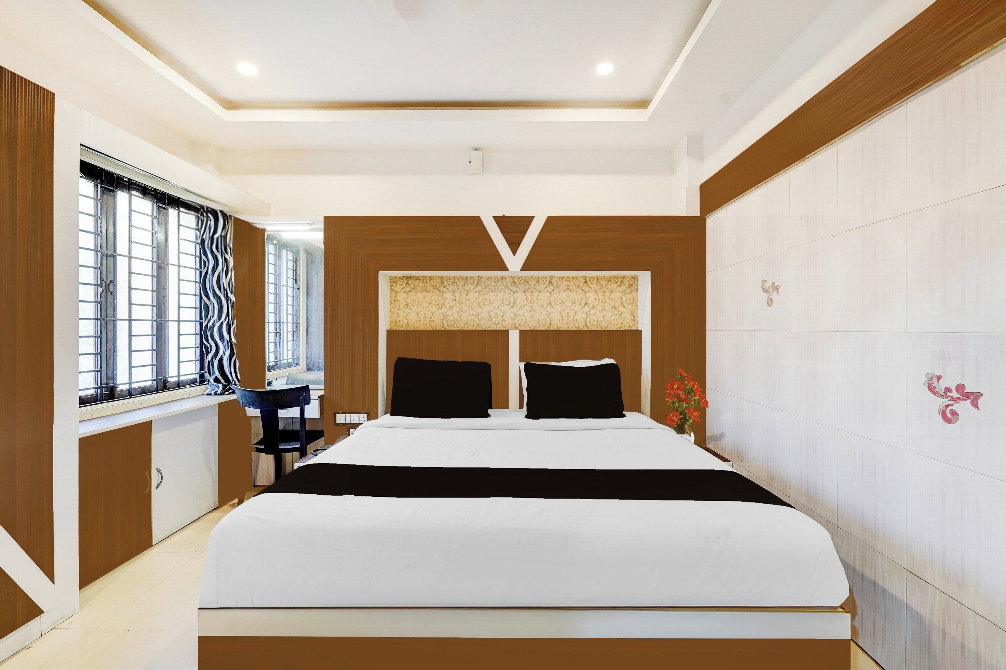 Un dormitorio moderno con una cama grande, un escritorio y un ventanal con cortinas.