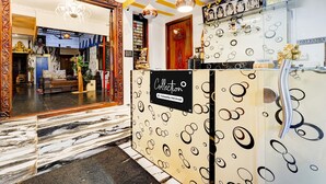 Un comptoir d’accueil avec une pancarte indiquant qu’il est mis à la disposition des employés de l’entreprise, un miroir agrémenté d’objets décoratifs et un sol à motifs.