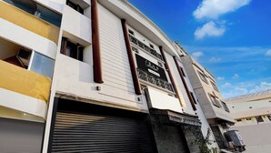 Un bâtiment avec un volet fermé, une enseigne et un ciel dégagé.