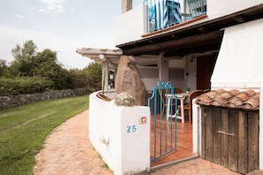 A property with a paved entrance, a stone pillar with the number 25, a blue gate, and a wooden door. - Vera Holiday Home by Wonderful Italy (Olbia)