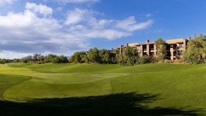 Golfkenttä, jossa on klubitalo ja taustalla näkyy asuinrakennuksia.