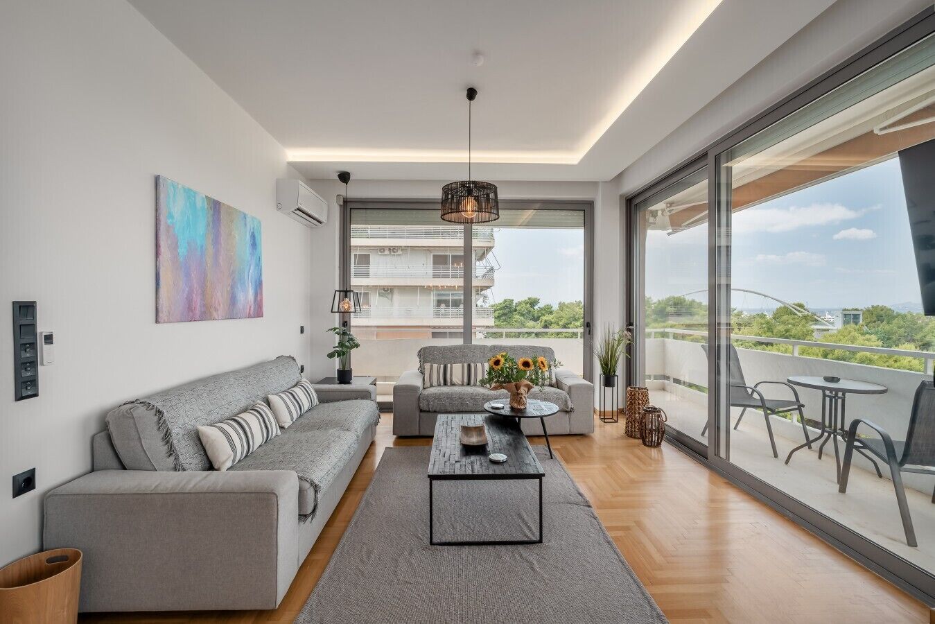 A modern living room with a sofa, coffee table, and a view of the city.