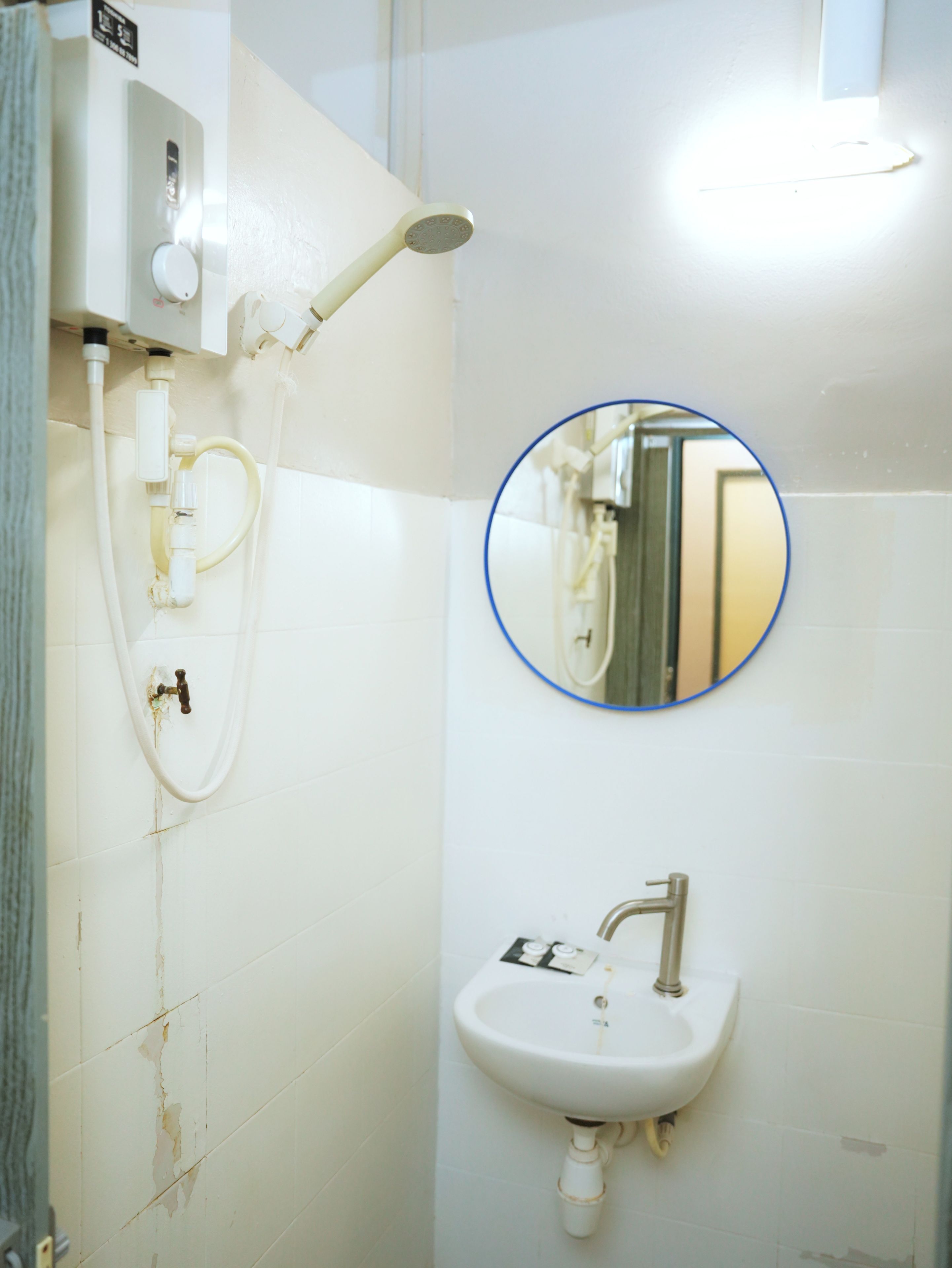 A bathroom with a white sink, a mirror, and a shower.