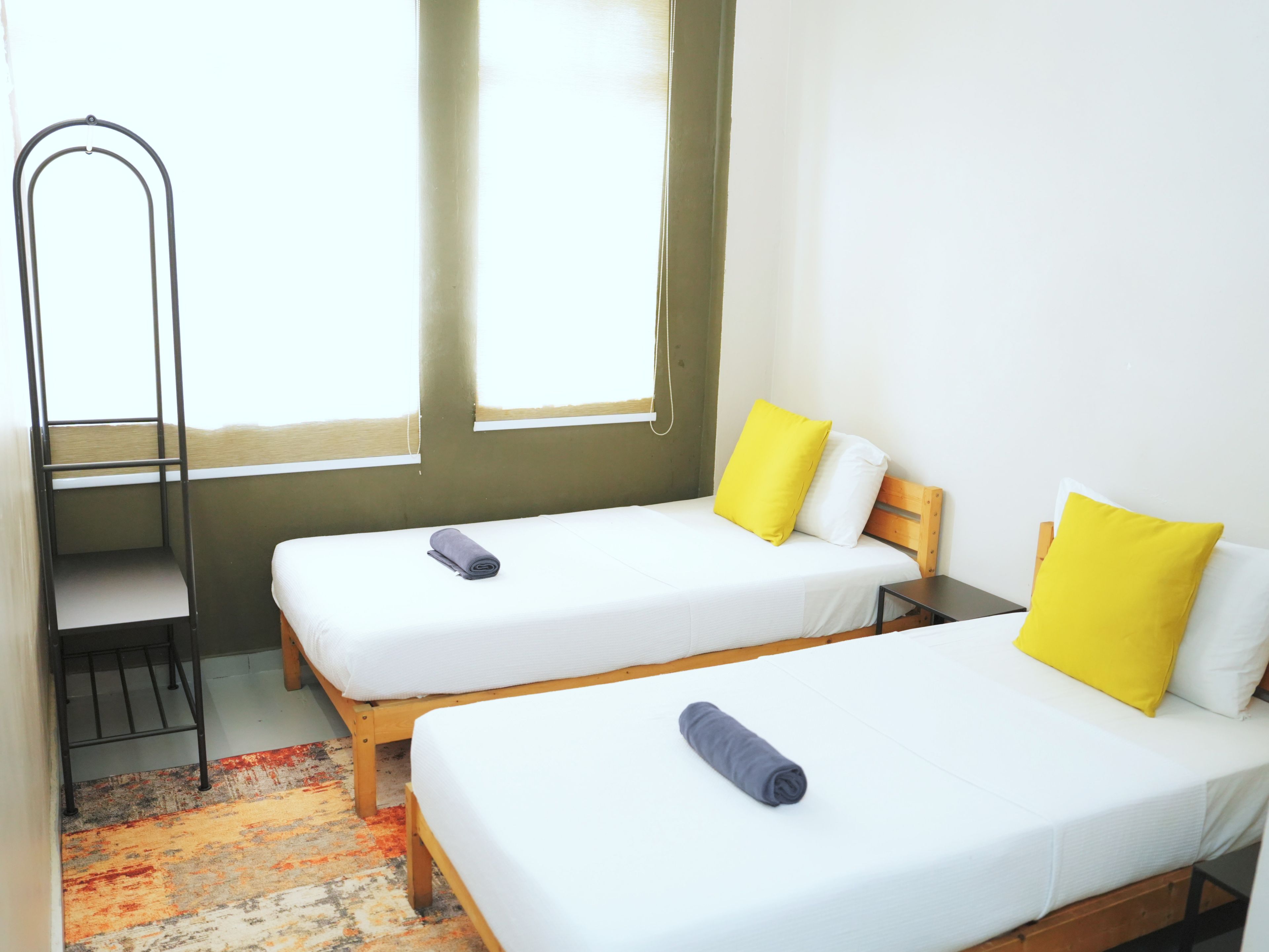 Una habitación con dos camas individuales, un escritorio y una silla.