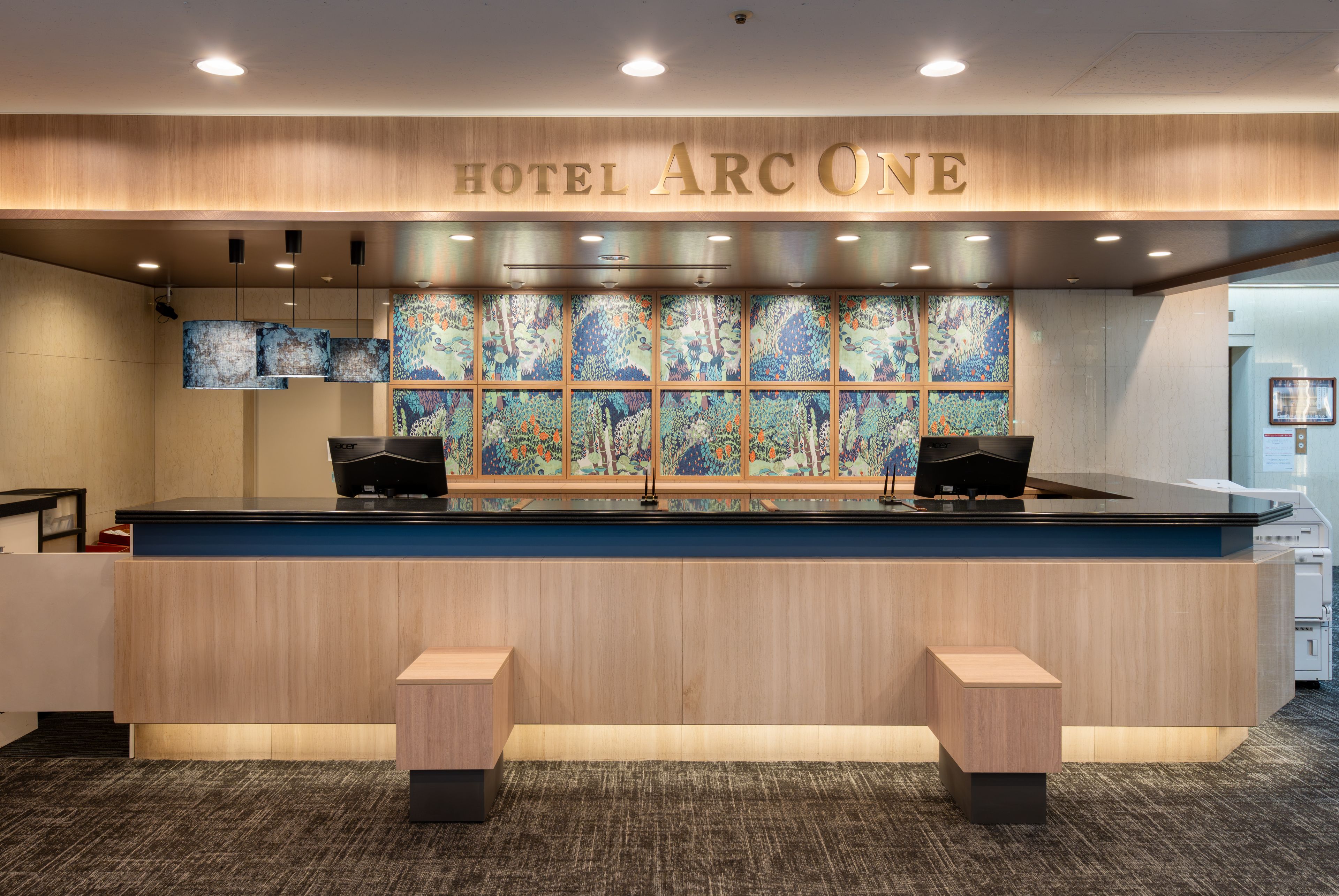 A hotel reception desk with a large sign reading 'HOTEL ARCONE' above it.