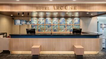 A hotel reception desk with a large sign reading 'HOTEL ARCONE' above it.