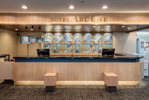 A hotel reception desk with a large sign reading 'HOTEL ARCONE' above it. - HOTEL ARC ONE OmiyaNakaurawa Ekimae (Saitama-shi)