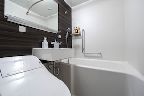A modern bathroom with a white sink, mirror, and bathtub. - HOTEL ARC ONE OmiyaNakaurawa Ekimae (Saitama-shi)