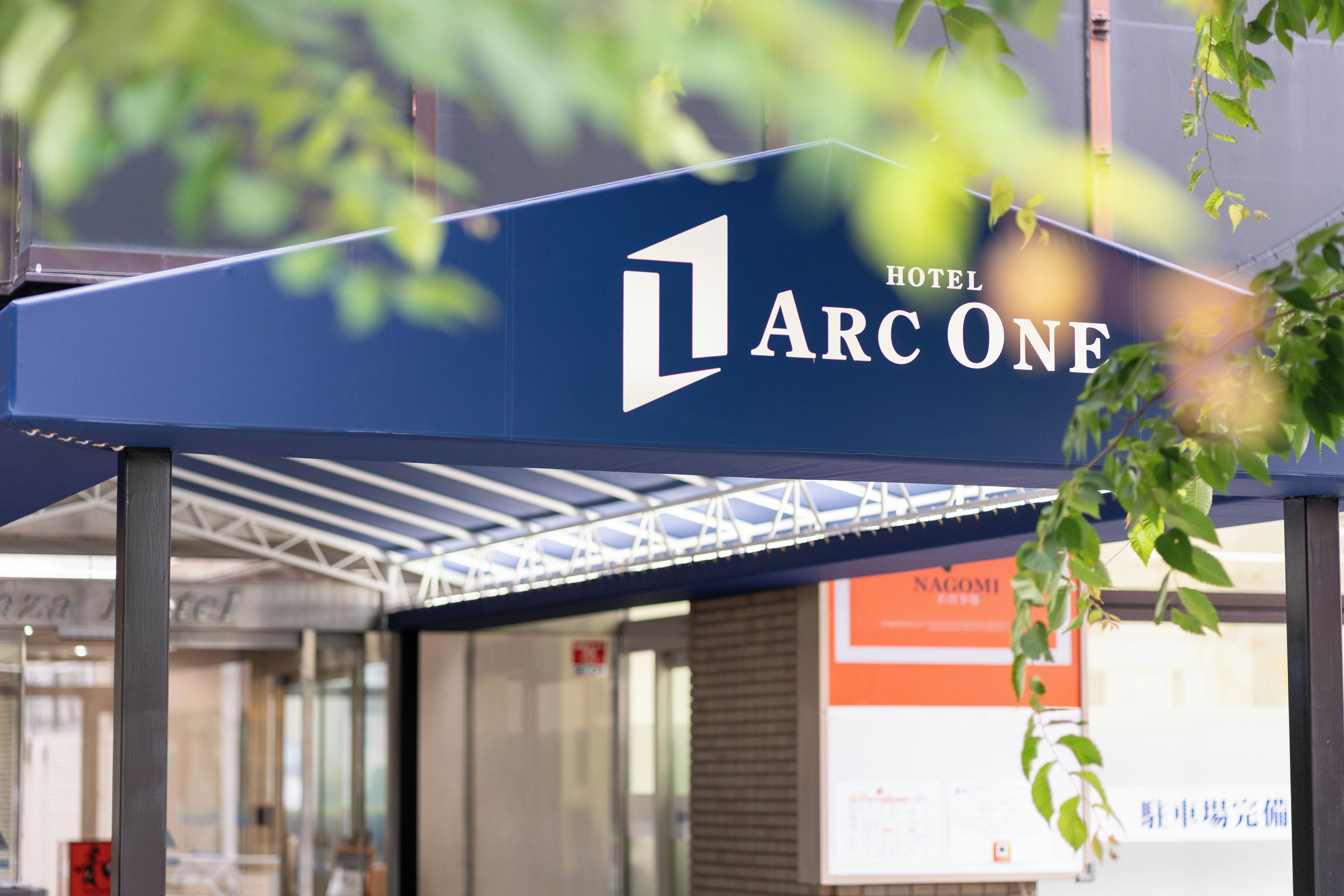 A hotel sign with the name 'ARC ONE' and a partial view of the building's structure.