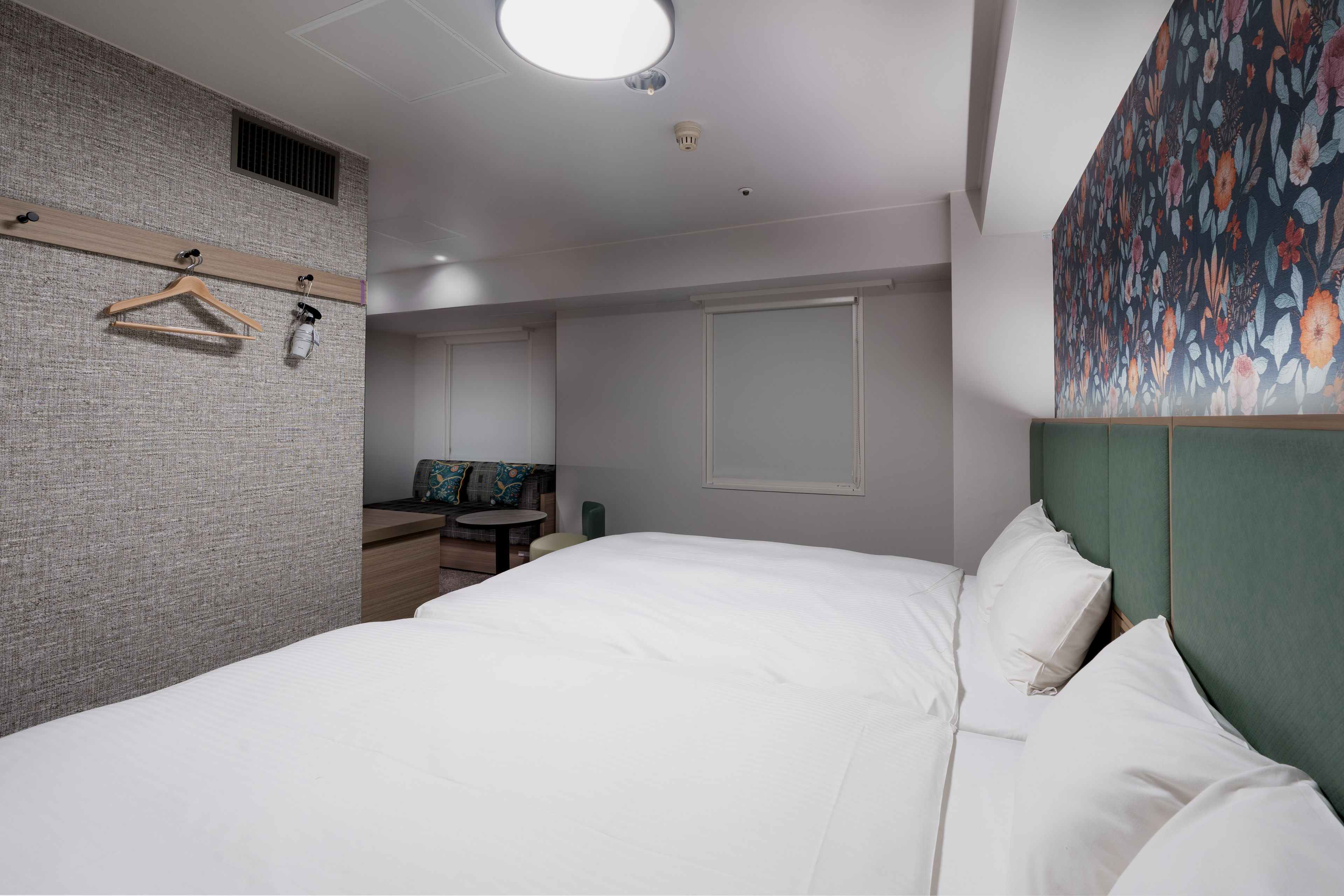 Habitación de hotel con una cama grande, un escritorio, una silla y un armario.