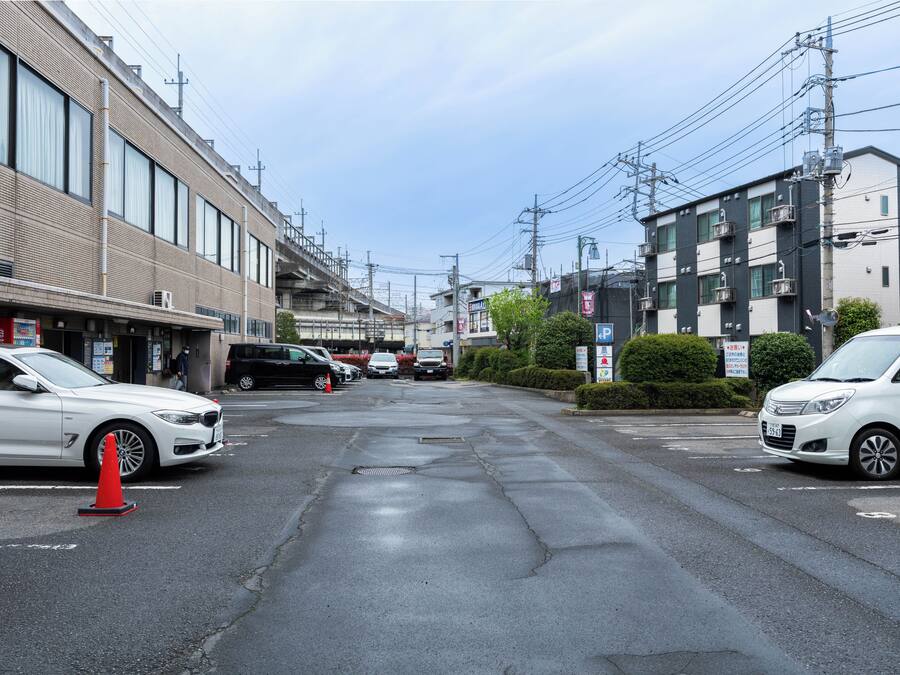 Una calle con coches aparcados, edificios y postes de electricidad.