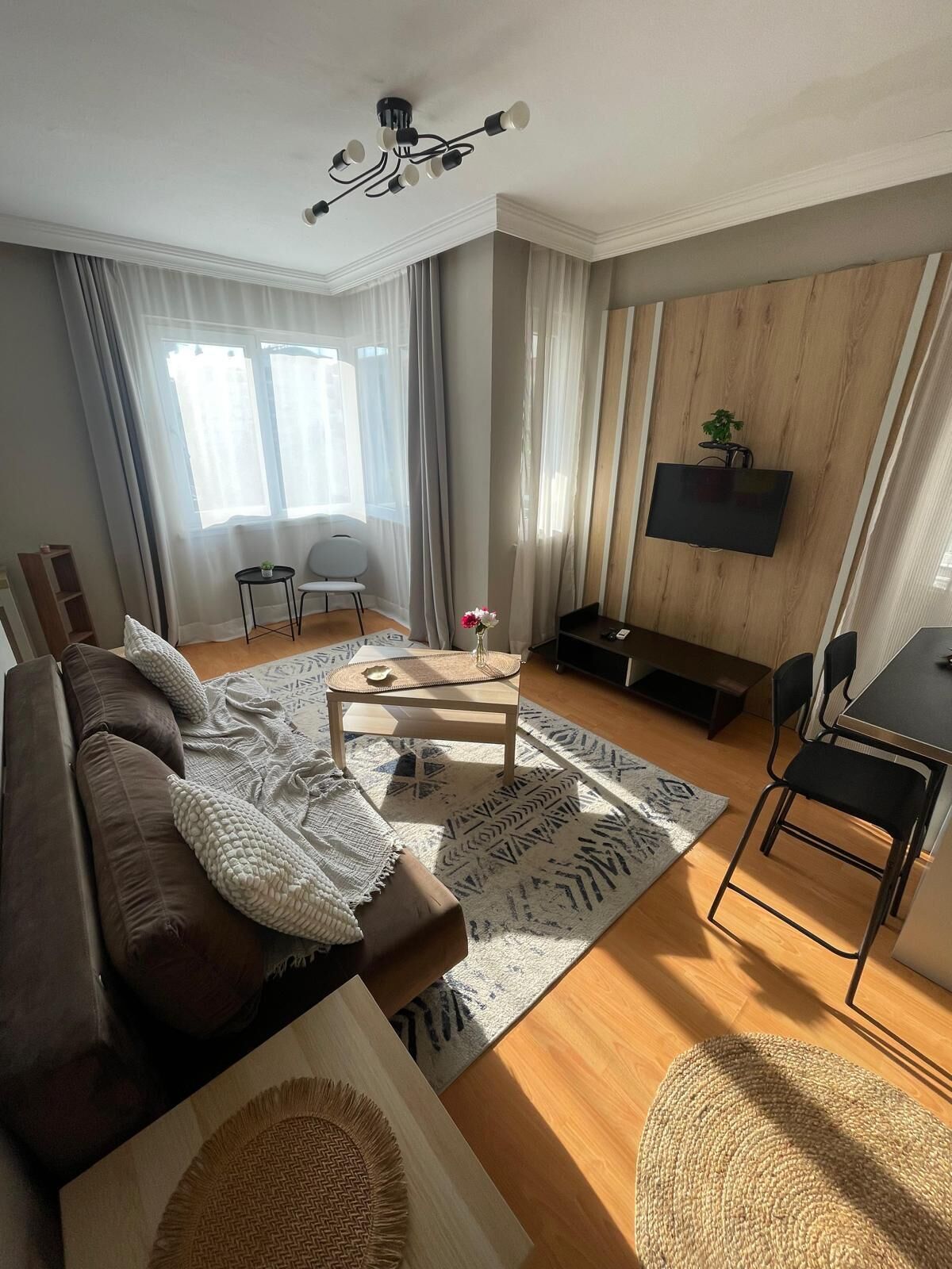 Una sala de estar moderna con sofá, mesa de centro y televisor.