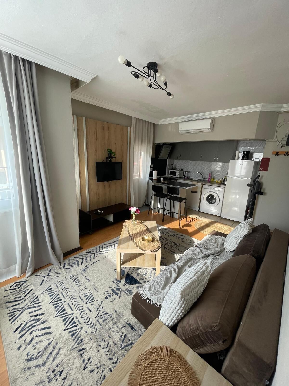 A modern living room with a sofa, coffee table, and a TV mounted on the wall.