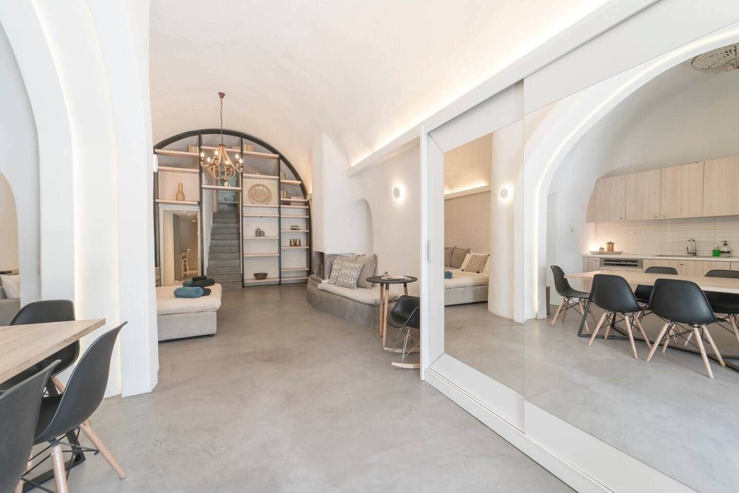 Un interior moderno con zona de comedor, un área de estar con sofá y una cocina.