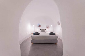 Ein modernes Schlafzimmer mit einem Bett, Nachttischen und Wandleuchten.