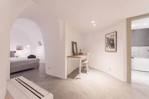 Ein modernes, minimalistisches Schlafzimmer mit Bett, Nachttisch und Schreibtisch mit Stuhl.