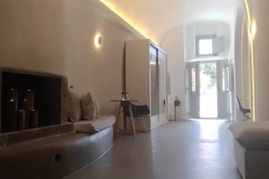 A modern interior with a fireplace, seating area, and a view of the outdoors. - Villa LuxL Winery Villa (Mesaria)