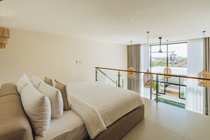 Et soveværelse med en stor seng, en balkon med gelænder og udsigt til bygninger.