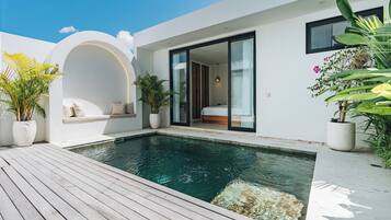 A modern house with a swimming pool, a built-in bench, and potted plants.