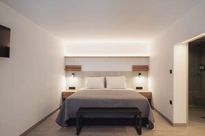 Ein modernes Schlafzimmer mit einem Bett, Nachttischen und einer Bank.