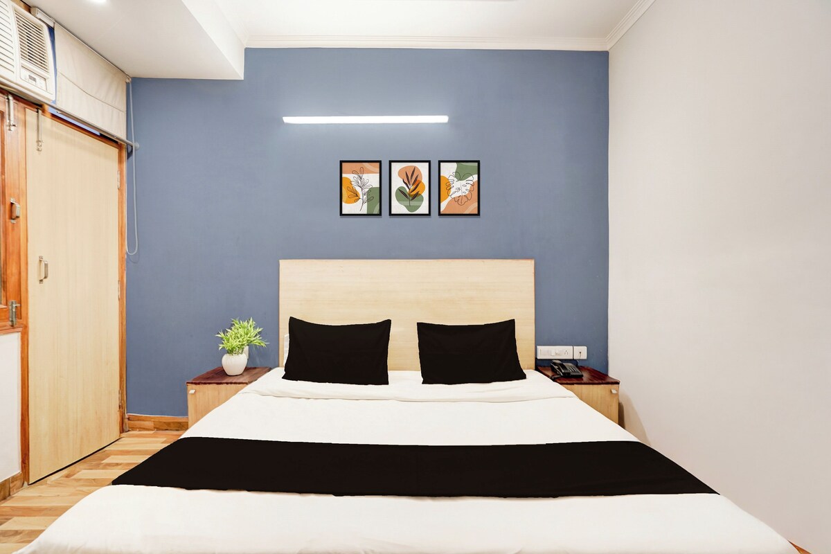 Un dormitorio con cama, mesita de noche, aire acondicionado instalado en la pared y armario de madera.