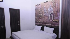Une chambre à coucher avec un lit, deux portes et une fresque murale.