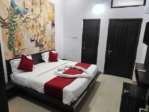 A hotel room with a bed, a wall-mounted TV, and a door.