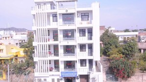 Un hôtel à plusieurs étages, doté de balcons et d’une enseigne indiquant la présence d’un restaurant.