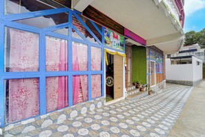 A building with a blue-framed window, a tiled entrance, and a green wall. - Collection O Murugan Temple Ooty (Ooty)