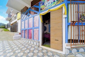 Un edificio con entrada de baldosas y ventana con marco azul.
