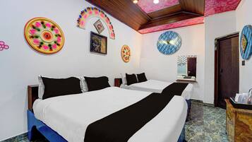 A hotel room with two beds, a wooden ceiling, and decorative wall art.