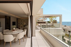 Un espace de restauration extérieur moderne offrant une vue sur la mer.