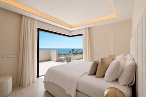 Une chambre d’hôtel avec un grand lit, un balcon donnant sur la mer et un design moderne au niveau du plafond.