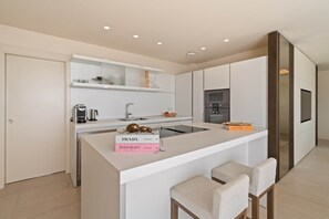 A modern kitchen with a central island, built-in appliances, and a minimalist design. - RDR574 Beachfront Luxury 4-Bed Penthouse in Velaya (Estepona)